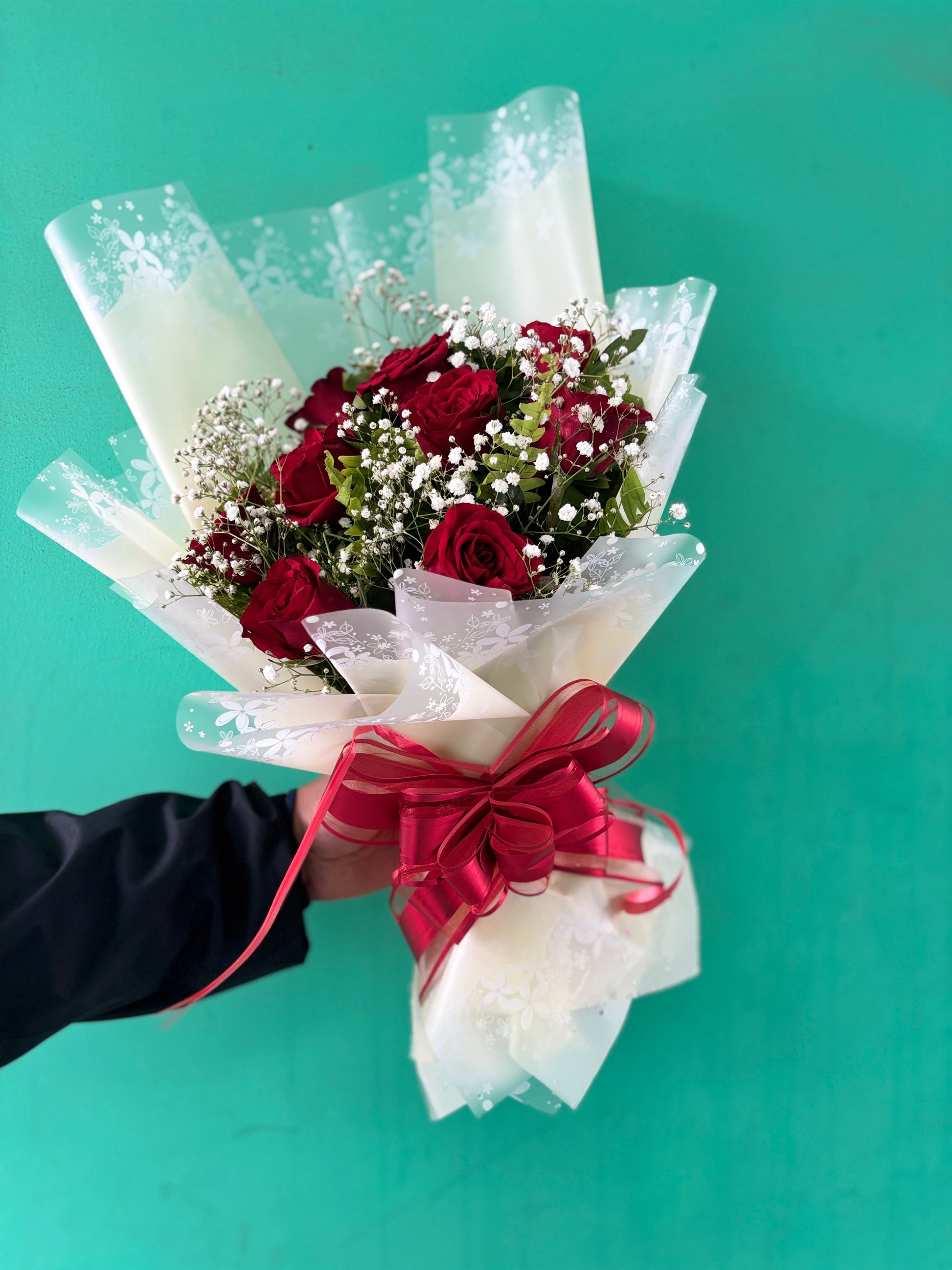 Hand holding dozen red roses bouquet perfect romantic surprise gift delivery